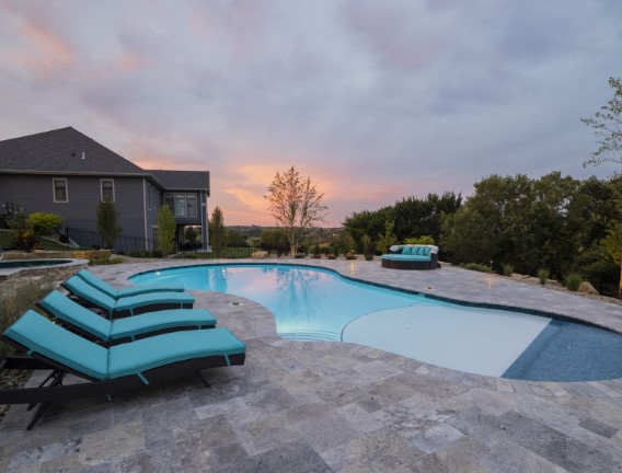 Lounge chairs around a pool with moody clouds - Swimming Pools Service & Repair in Abilene, KS